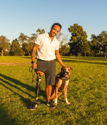 Brian, an OPRA™ Implant System patient, outdoors with his dog.