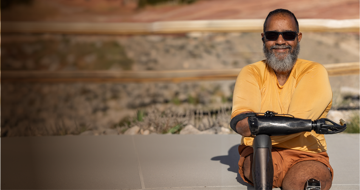 An OPRA™ Implant System patient seated outdoors in casual setting.