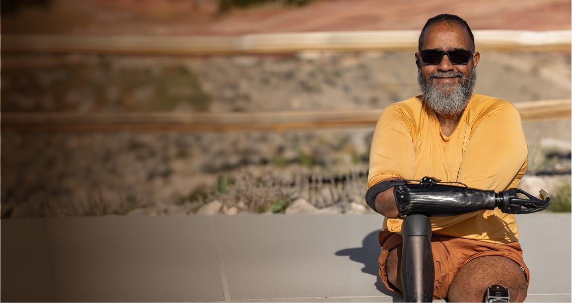 An OPRA™ Implant System patient seated outdoors in casual setting.