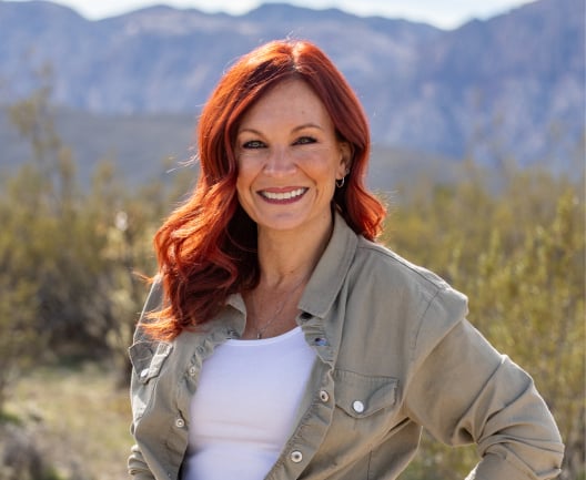 Closeup of Stacey in desert landscape.