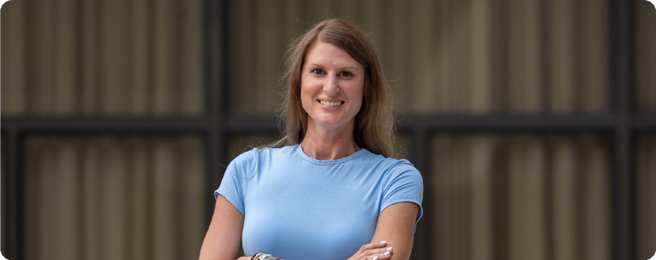 Gini, an OPRA™ Implant System patient, standing outdoor smiling.